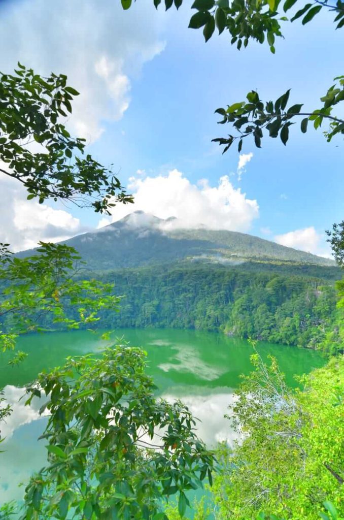 Danau Tolire di Maluku Utara dengan air tenang dikelilingi pepohonan lebat saat senja