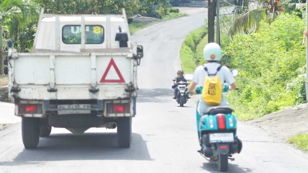 Pengendara di Bali menunjukkan keterampilan menyalip sebagai bagian dari seni bertahan hidup di jalan.