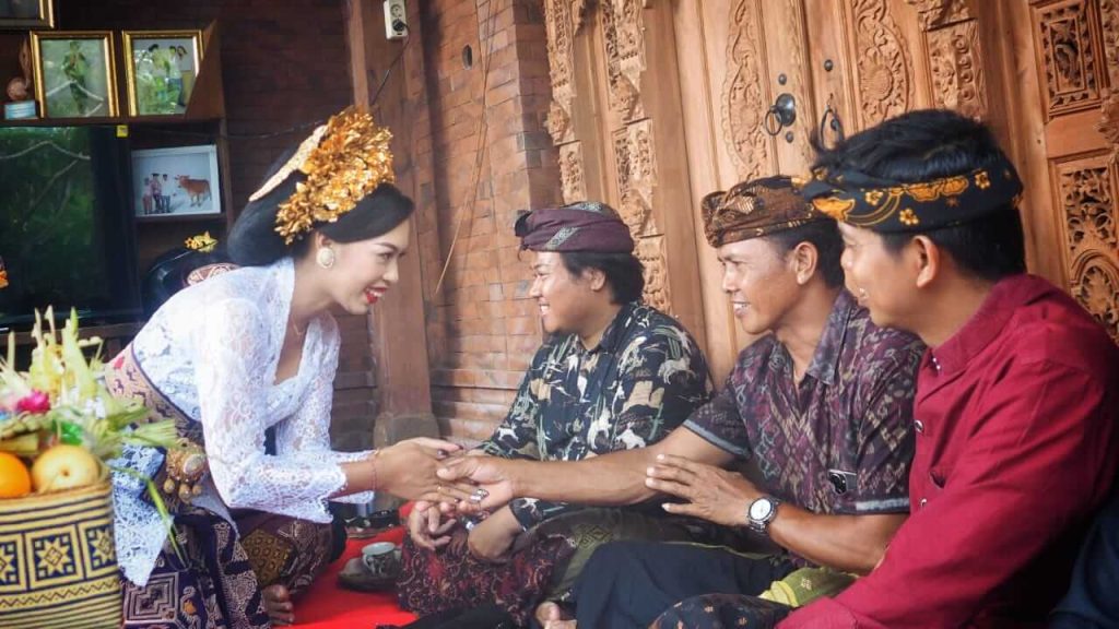 Kadek, perempuan Bali berusia 24 tahun, tersenyum mengenakan busana adat pernikahan dalam prosesi tradisional.