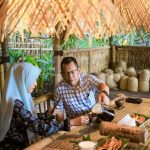 Kapolda Maluku Utara Irjen Pol. Drs. Waris Agono, M.Si. bersama istri menikmati kopi dan kudapan tradisional di warung bambu dengan nuansa budaya lokal.
