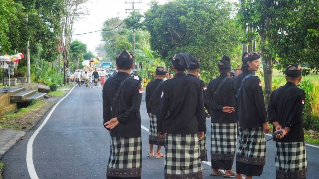 Pecalang Bali mengenakan kain poleng bersiap mengawal prosesi keagamaan sebagai simbol penjaga harmoni adat dan budaya.