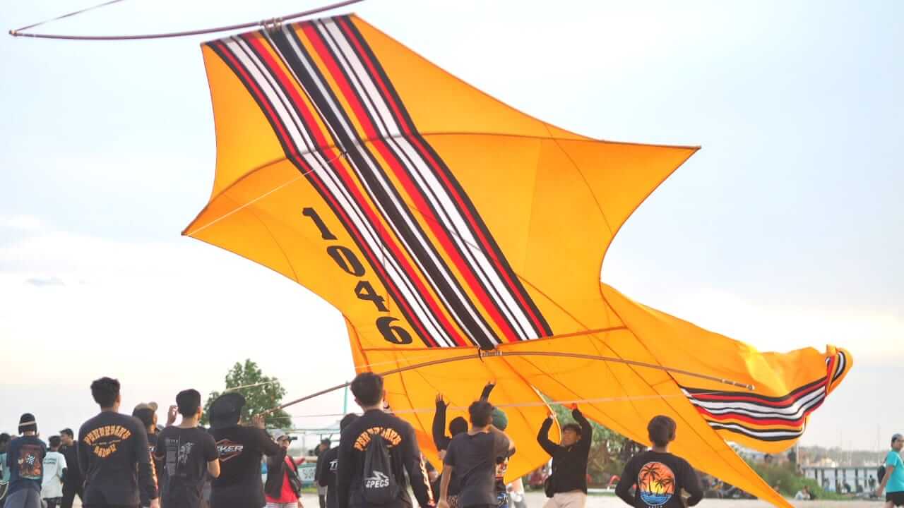 Tim menurunkan layang-layang Bebean di Pantai Mertasari saat festival budaya Bali.
