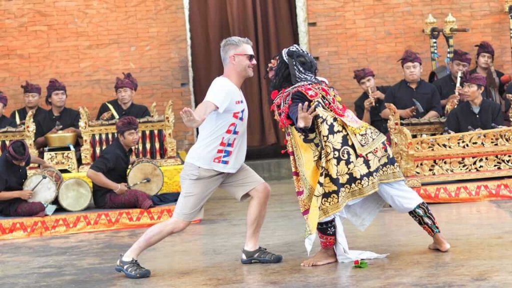 Tamu mancanegara menari bersama penari topeng Bali dalam pertunjukan tradisional.