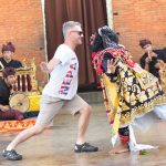 Tamu mancanegara menari bersama penari topeng Bali dalam pertunjukan tradisional.