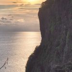 Pura Luhur Uluwatu siluet di tepi tebing dengan latar matahari terbenam yang memukau di Bali.