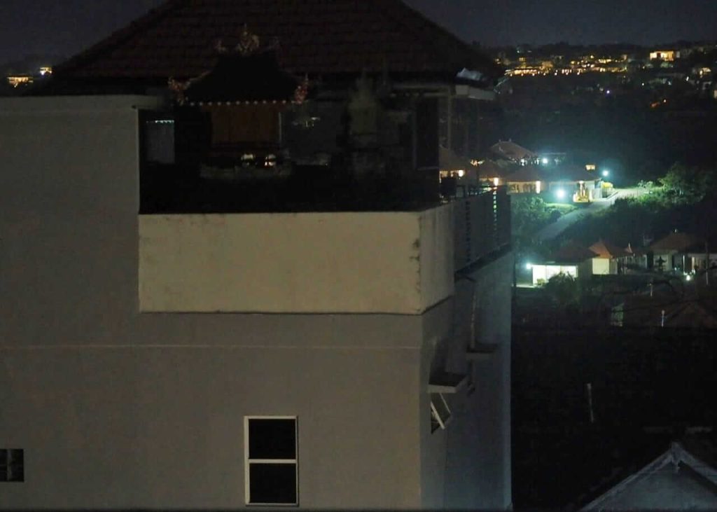 Satu rumah terlihat gelap akibat pemadaman listrik parsial di tengah rumah-rumah lain yang tetap terang.