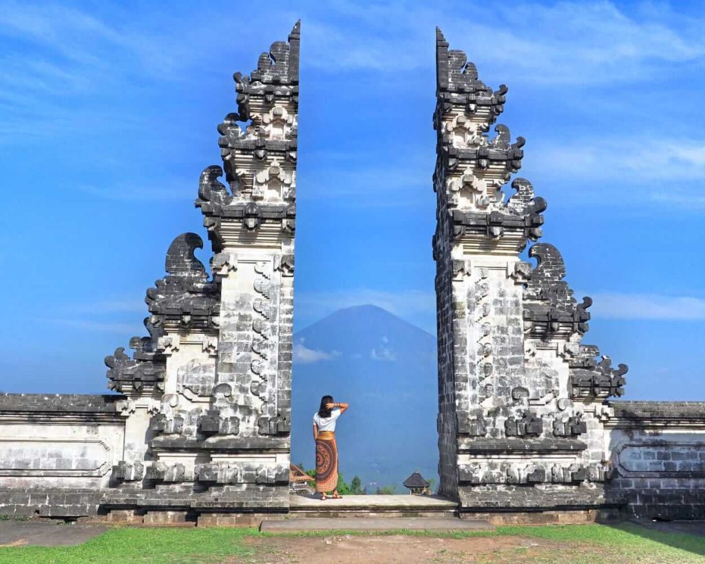 Wisatawan berpose di Gerbang Surga dengan latar Gunung Agung yang megah di Bali.