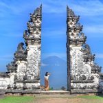 Wisatawan berpose di Gerbang Surga dengan latar Gunung Agung yang megah di Bali.