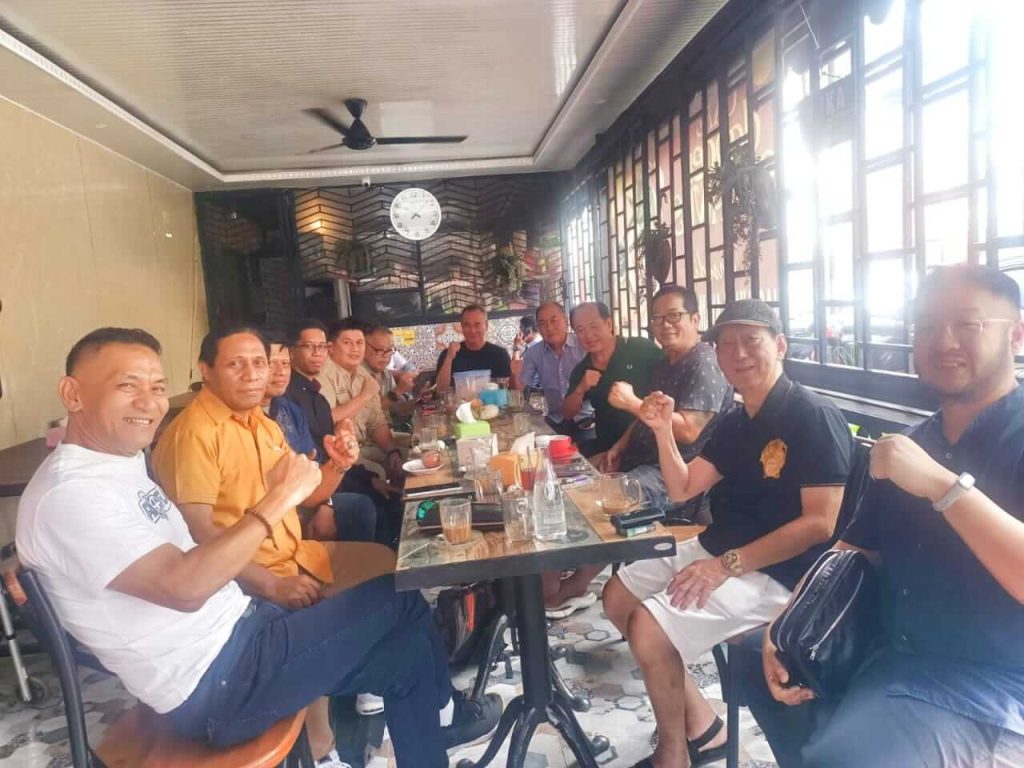 Brigjen Pol (Purn) Dr. Drs. Adeni Muhan Daeng Pabali duduk bersama tokoh-tokoh masyarakat Makassar dalam suasana santai sambil menikmati kopi pagi.