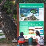 Dua anak membaca dengan serius papan informasi di kawasan Peninsula, Nusa Dua.