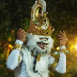 Pemeran tokoh Hanoman memasang topeng di balik layar sebelum pertunjukan dimulai.