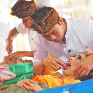 Remaja perempuan menjalani prosesi Metatah atau Potong Gigi dalam tradisi Hindu Bali.