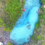 Pemandangan Danau Weekuri di Sumba Barat Daya dengan air biru jernih, dikelilingi savana dan tebing karang.