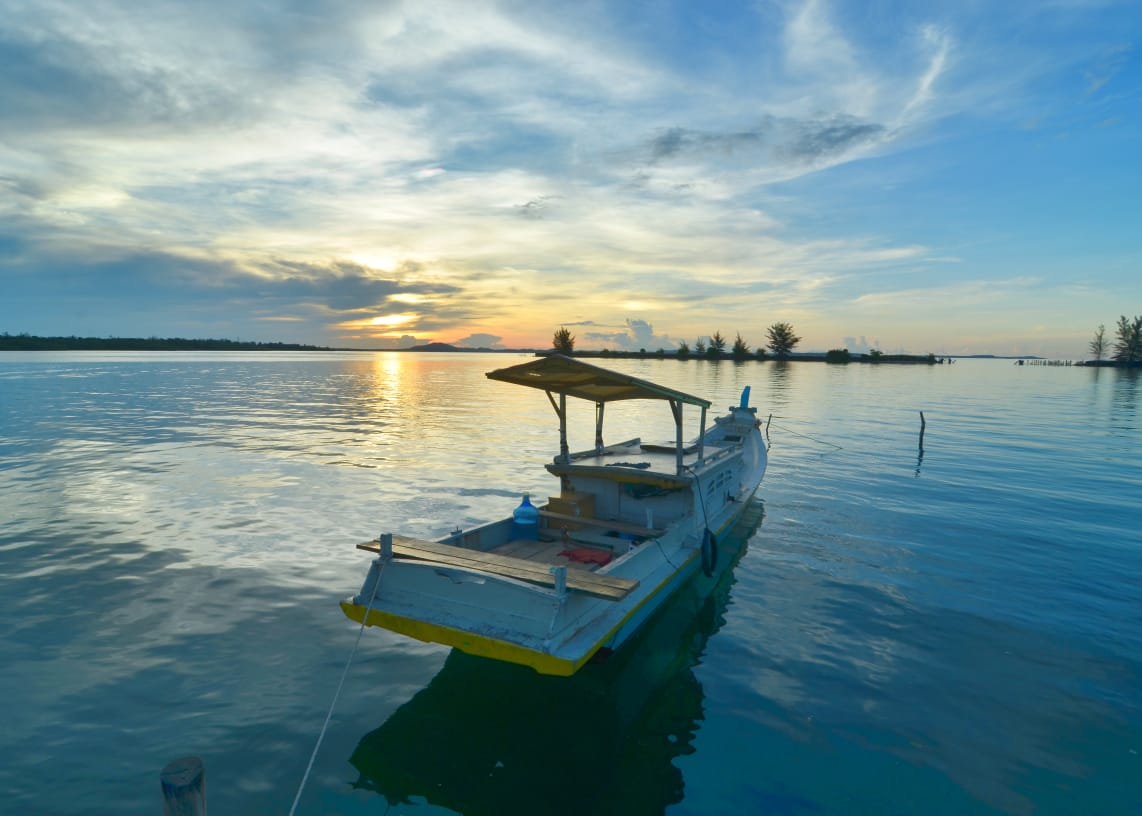 Perahu berlabuh di laut tenang sebagai simbol jeda hidup dan kebijaksanaan dalam menemukan arah