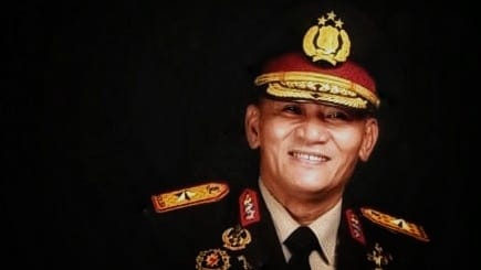 Brigjen Pol (Purn) Dr. Drs. Adeni Muhan Daeng Pabali, M.M. duduk dalam suasana reflektif, mengenakan batik, tampak tenang dalam suasana non-formal.