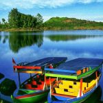 Deretan perahu berlabuh di Danau Ciwidey dengan latar permukaan air yang hening dan pegunungan berkabut.