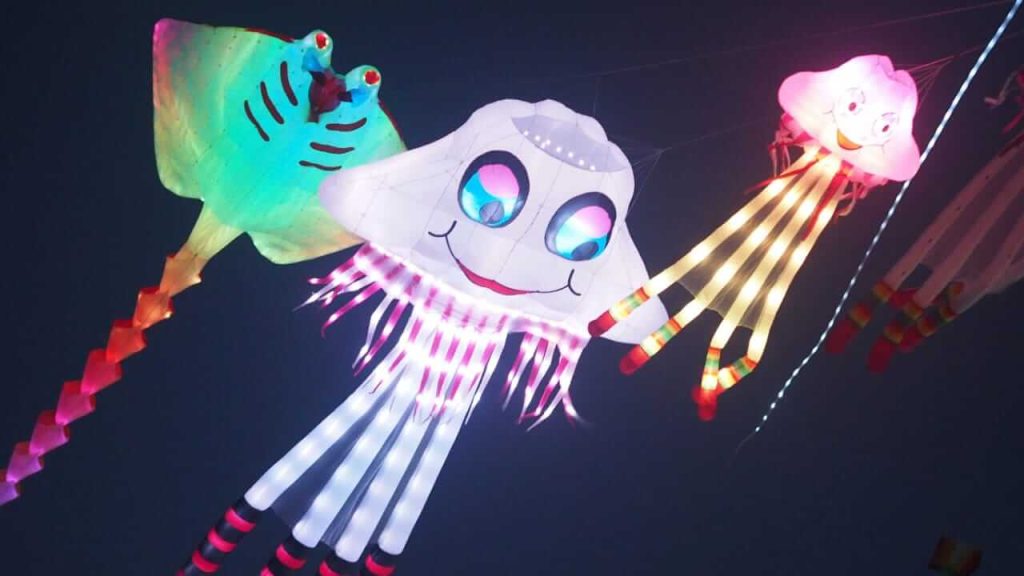 Sebuah layangan bercahaya terbang tinggi di langit malam, menjadi pusat perhatian penonton saat penutupan festival.