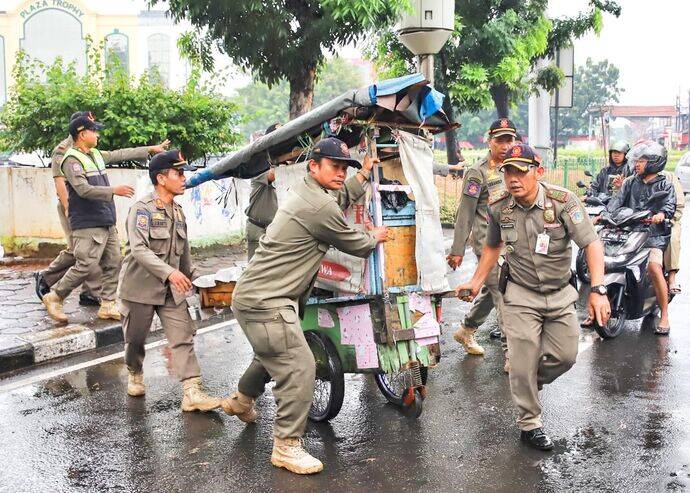 Petugas Satpol PP menertibkan gerobak pedagang kaki lima dalam operasi penertiban yang dilaksanakan Pemerintah Kota Jakarta.