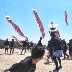 Tim bekerja sama menerbangkan layangan Janggan tradisional dengan bantuan angin.