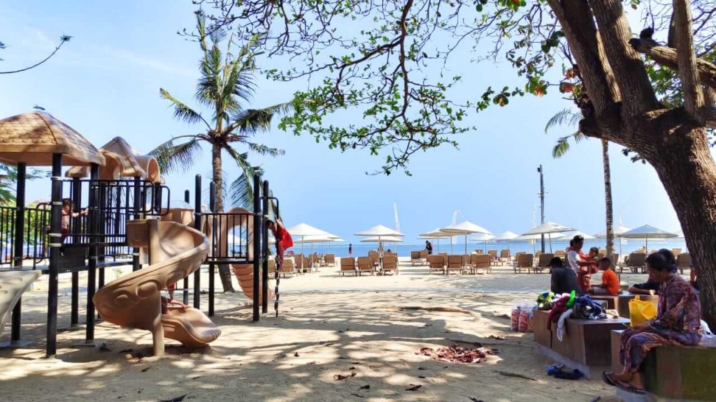 Taman bermain anak-anak di tepi Pantai Mertasari, Sanur, dengan pemandangan laut sebagai latar.