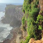 Tebing karang kokoh membingkai panorama laut lepas, menciptakan pemandangan dramatis.