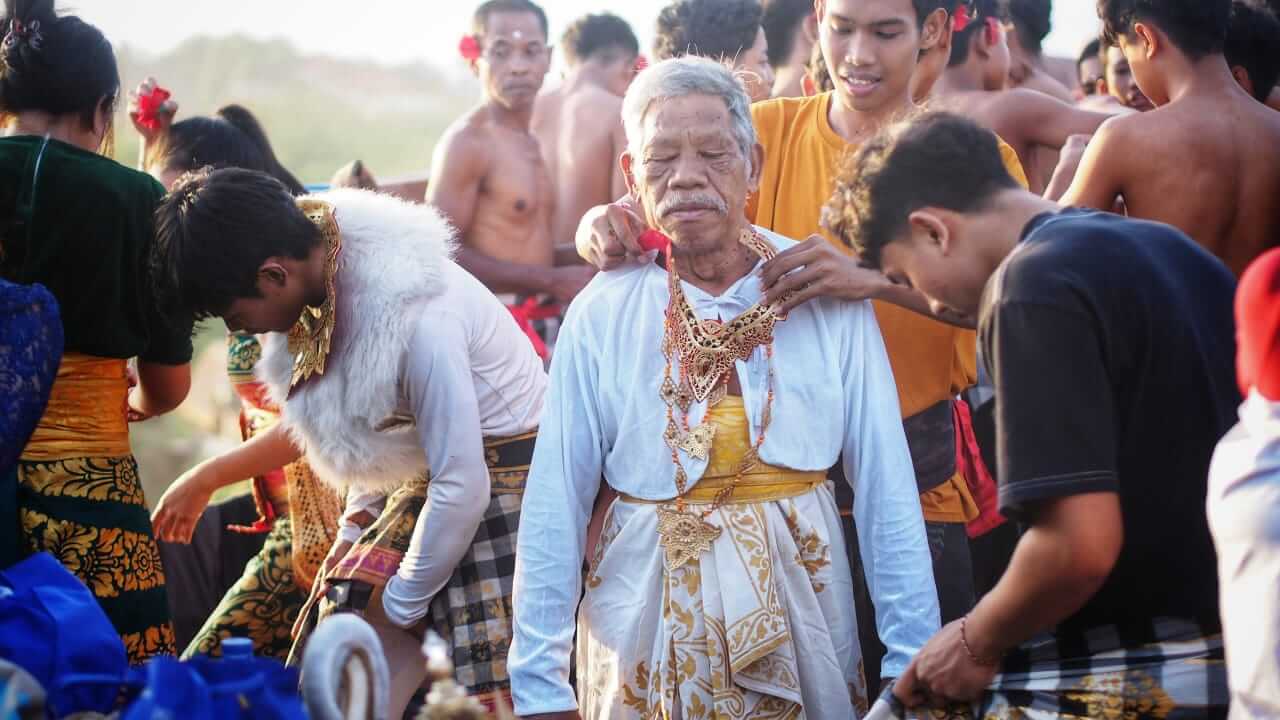 Seorang tetua mengajarkan keterampilan tradisional kepada generasi muda.