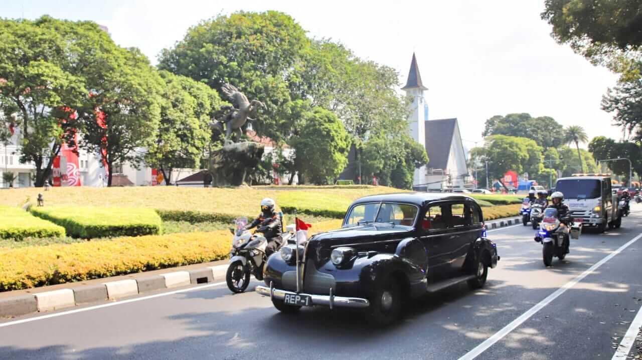 Wali Kota Jakarta Pusat Arifin dan Asisten Kesra DKI Ali Maulana Hakim menaiki mobil RI 1 era kemerdekaan saat Napak Tilas Proklamasi 2025.