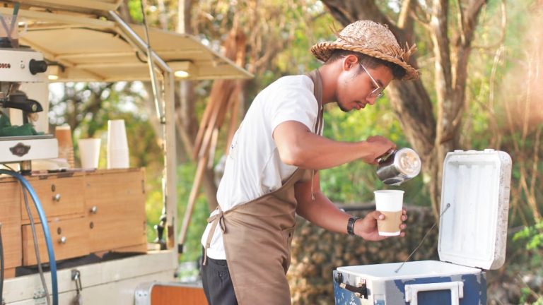 Calvin menyajikan kopi kepada pelanggan di Karang Boma Cliff dengan konsep kedai street coffee sederhana.
