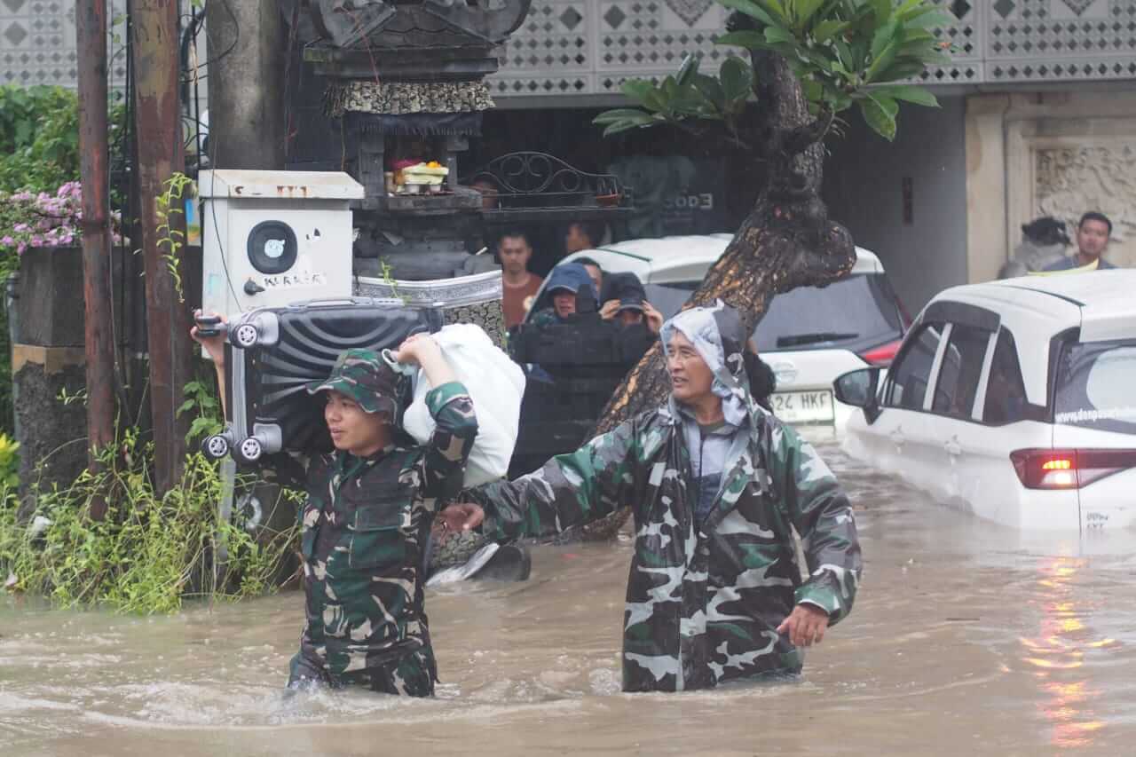 Danramil 1611-03/Kuta Mayor Arm I Putu Arimbawa membantu warga terdampak banjir di Bali.