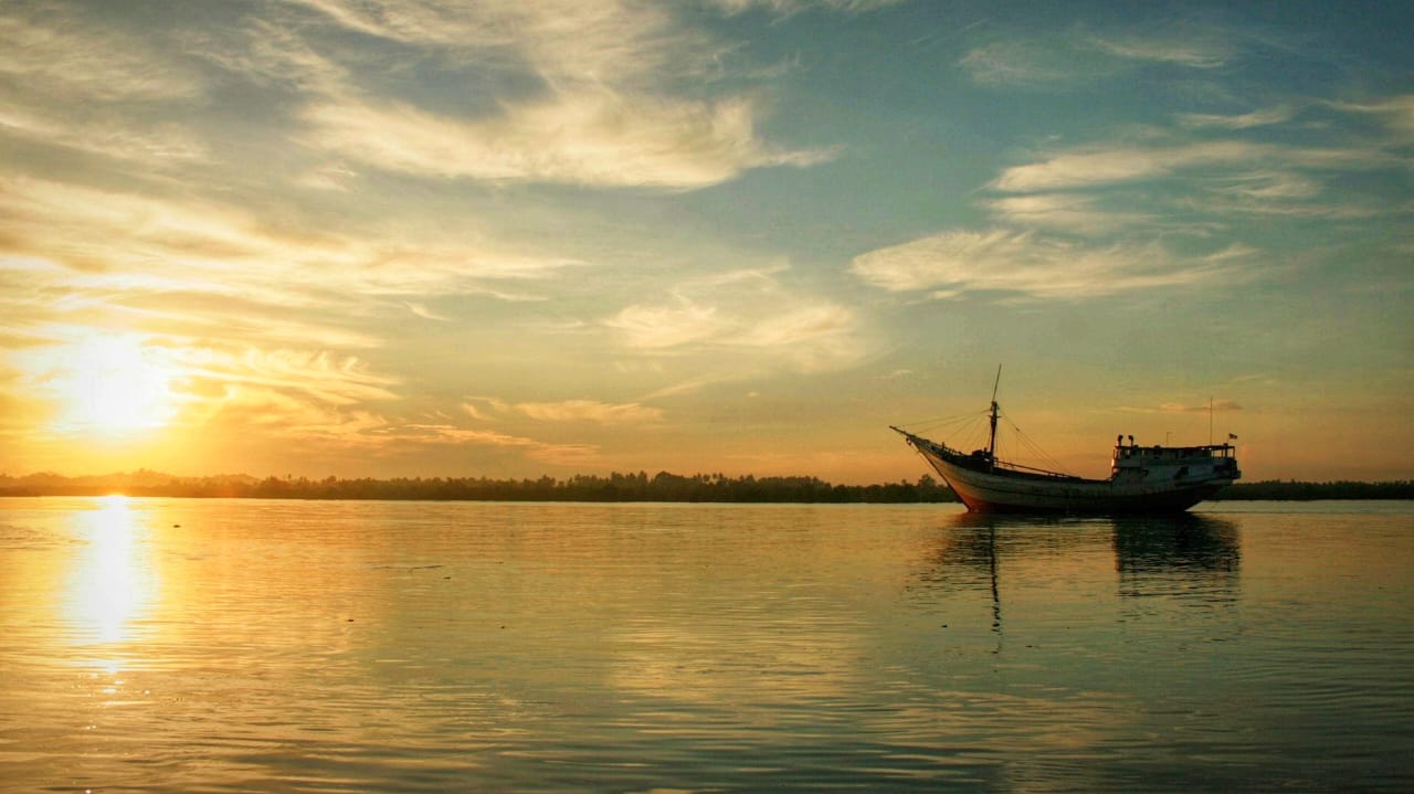 Perahu di lautan sebagai simbol perjalanan hidup penuh tujuan dan harapan.