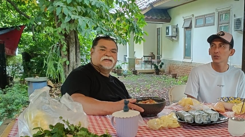 Seorang penjual bubur yang akrab menemani masa tua dengan kebersamaan sederhana di taman rumah