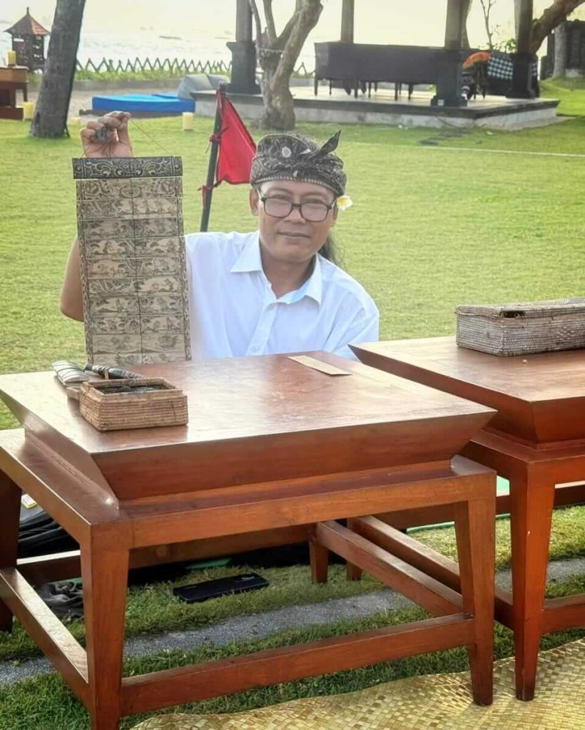 Komang Suweca ajarkan seni lontar kepada wisatawan di Hotel Ramayana Candidasa.