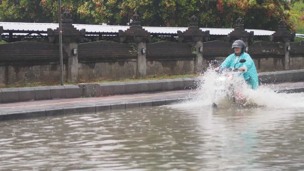 Pengendara sepeda motor melintasi genangan banjir di Bali, 10 September 2025.