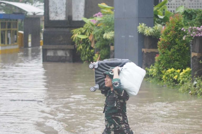 Prajurit TNI membantu evakuasi barang milik warga dari lokasi banjir di Bali.