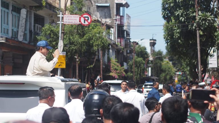 Presiden kembali menyapa warga dari atas kendaraan yang ditumpanginya.