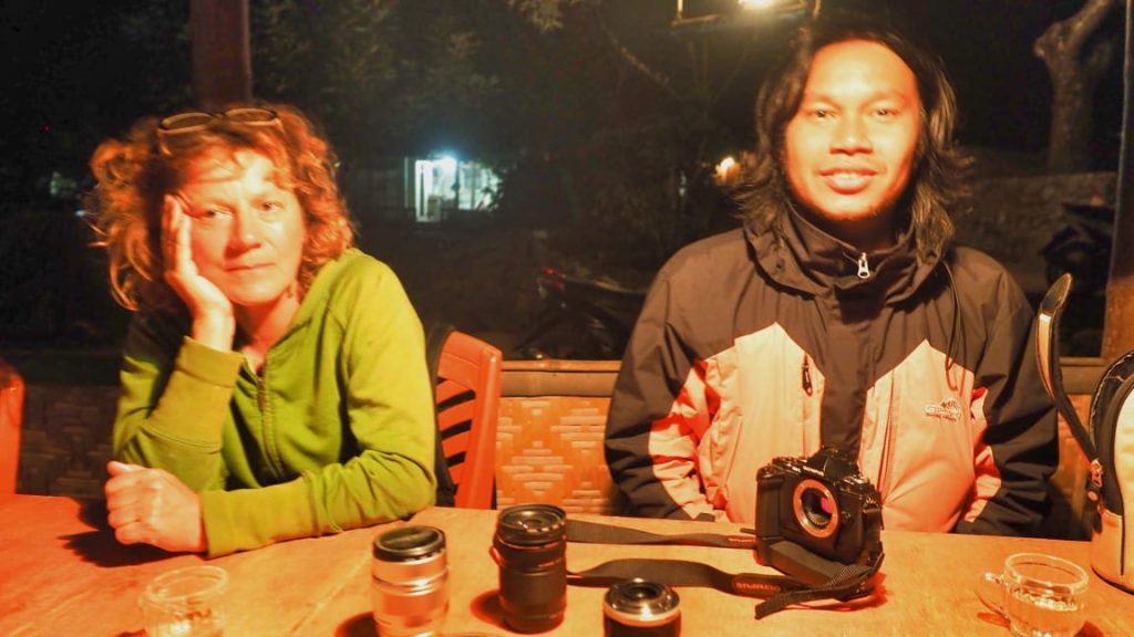 Dua orang dari negara berbeda berbincang akrab dengan ekspresi terbuka dan bahasa tubuh yang santai.