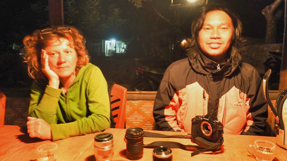 Dua orang dari negara berbeda berbincang akrab dengan ekspresi terbuka dan bahasa tubuh yang santai.