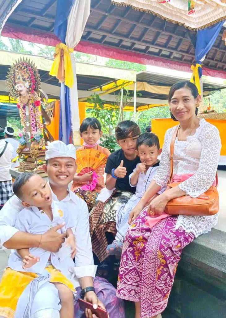 Pasangan suami istri di Bali sedang bekerja di tempat terpisah, menggambarkan kehidupan modern dengan dua sumber penghasilan.