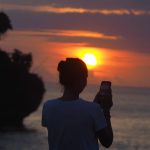 Pemandangan Honeymoon Beach di Jimbaran dengan pasir putih dan tebing karang di sekelilingnya.