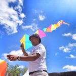 Kadek Armika membantu temannya asal Swedia menerbangkan layangan dalam sebuah acara budaya di Bali.