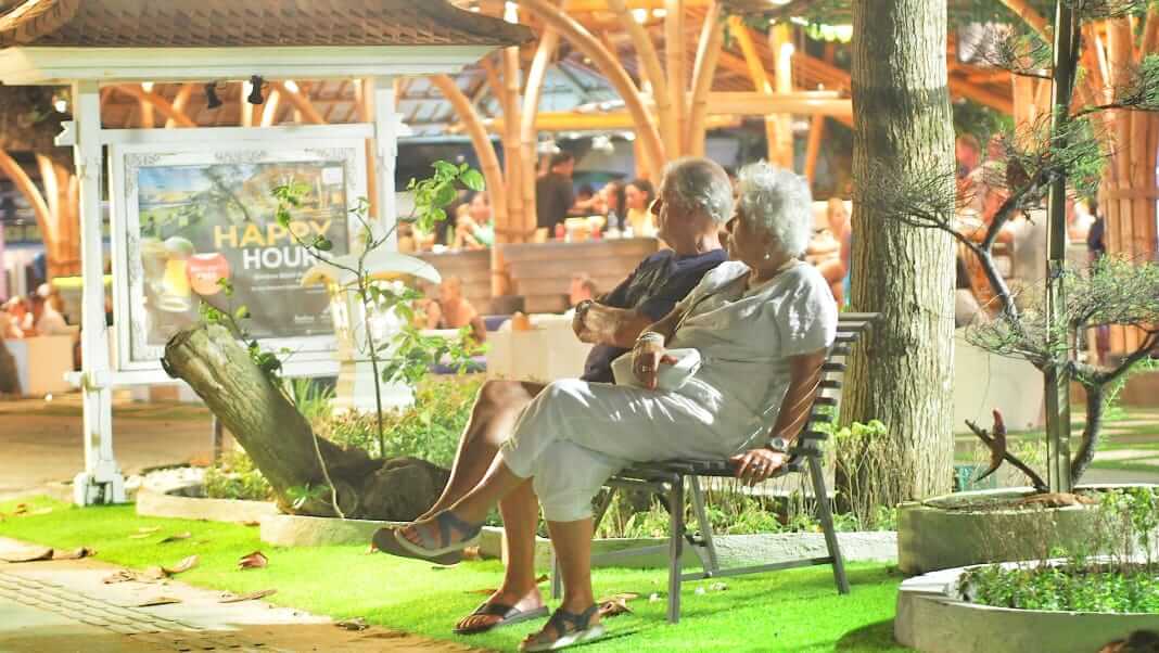 Dua orang berjalan berdampingan di bawah cahaya senja, melambangkan kehangatan dan kebersamaan.