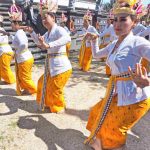 Perempuan Bali menari dalam sebuah upacara adat dengan busana tradisional.