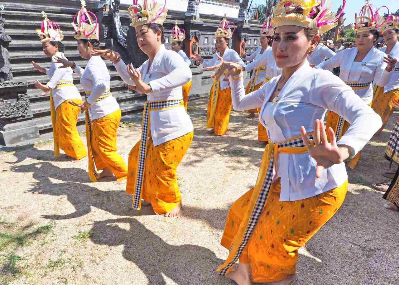 Perempuan Bali menari dalam sebuah upacara adat dengan busana tradisional.
