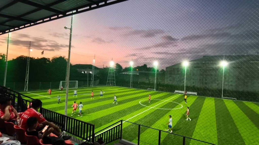 Pemain mini soccer sedang bertanding di lapangan kecil dengan suasana permainan yang cepat dan intens.