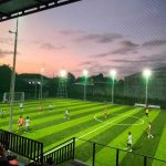 Pemain mini soccer sedang bertanding di lapangan kecil dengan suasana permainan yang cepat dan intens.