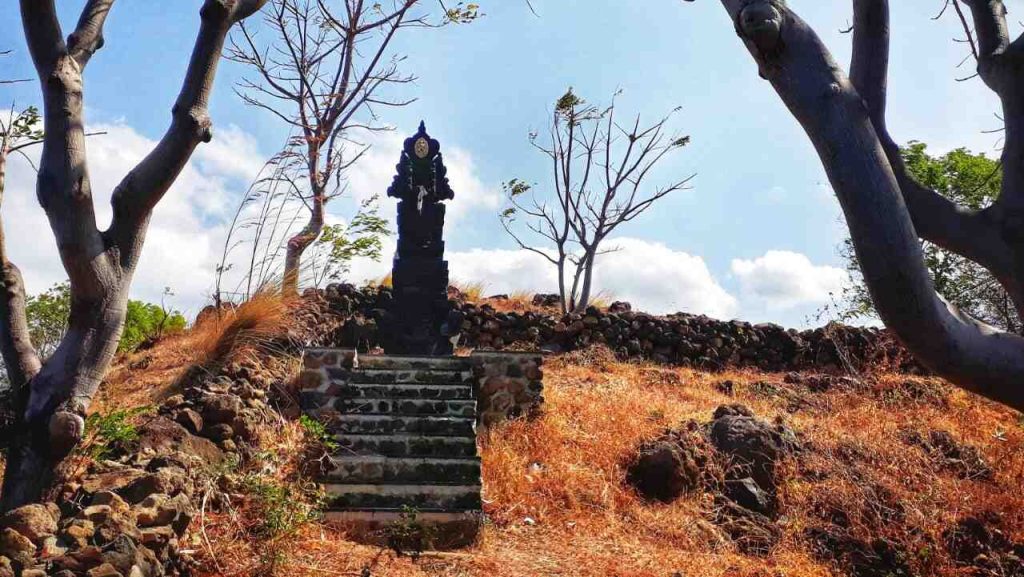 Pelinggih atau bangunan suci umat Hindu Bali di area pura dengan latar langit cerah.