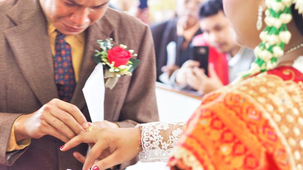 Pasangan pengantin berdiri berdampingan setelah prosesi pernikahan.