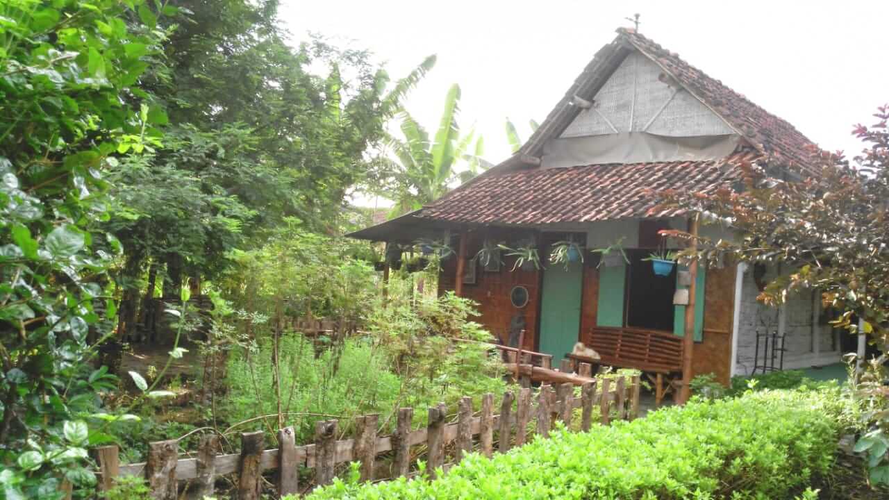Rumah sederhana bergaya tradisional berdiri di tengah lingkungan alami di Bali.