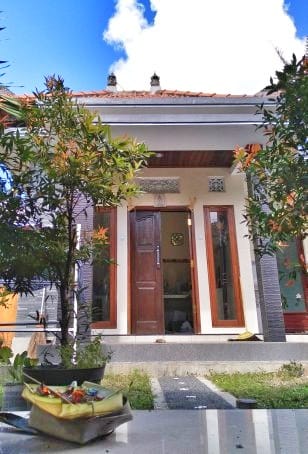 Rumah tradisional Bali dengan arsitektur terbuka dan halaman luas.