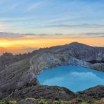 Pemandangan sunrise di Danau Kelimutu dengan cahaya matahari yang menyinari tiga kawah berwarna.